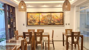 Un comedor con muebles de madera y un cuadro grande en la pared.