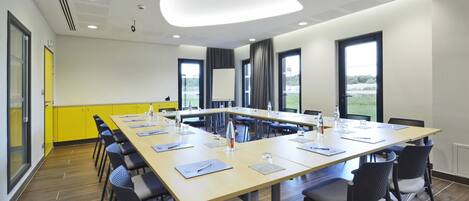 A conference room with a long table, chairs, and a modern ceiling design.