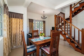 A dining area with a wooden table, chairs, and a chandelier. - Captain's Villa (Mahé Island)
