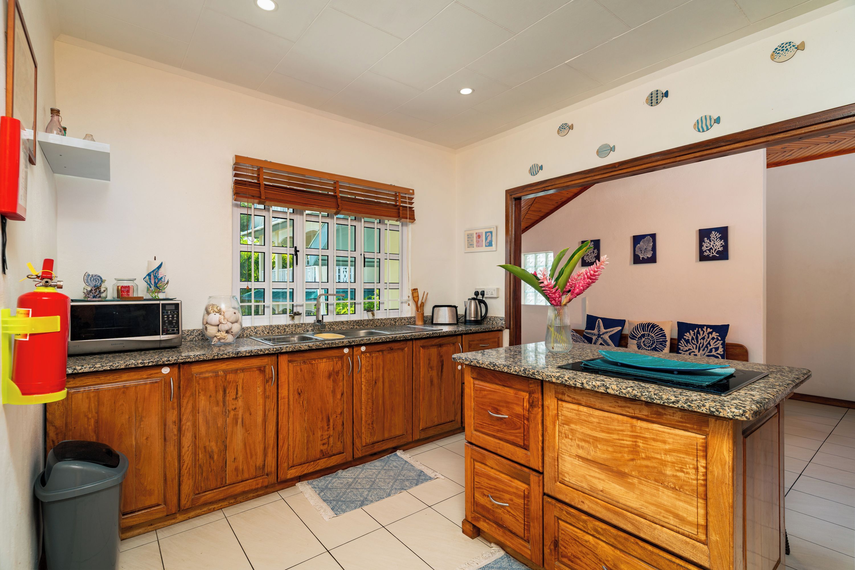 A kitchen with wooden cabinets, a microwave, and a sink.