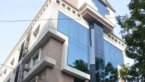 Un hotel con fachada moderna, un restaurante en la planta baja e una bandera que indica su ubicación.