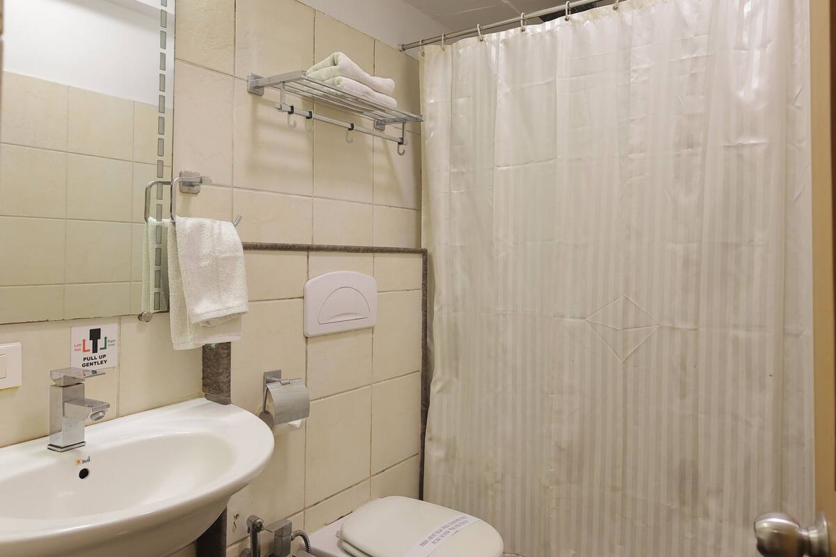 Un baño con lavamanos, inodoro y cortina de ducha.