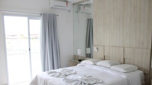 Una habitación de hotel con cama, baño y balcón.