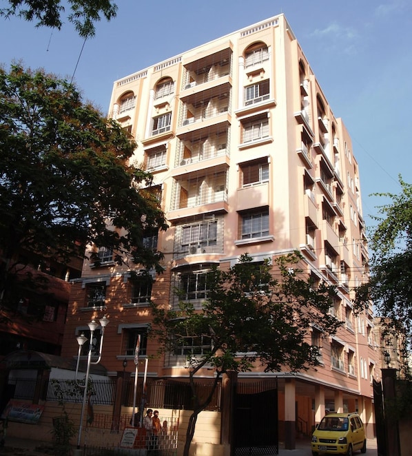 A multi-story building with balconies and a gated entrance.