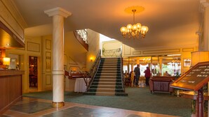 A hotel lobby with a marble reception desk, a staircase, and a chandelier. - Hansa Hotel (Swakopmund)