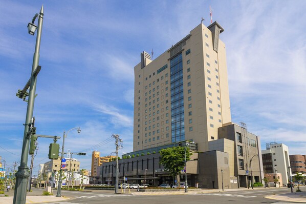 A tall hotel with a modern design, featuring a prominent glass facade and multiple floors. - Hotel Aomori (Aomori)