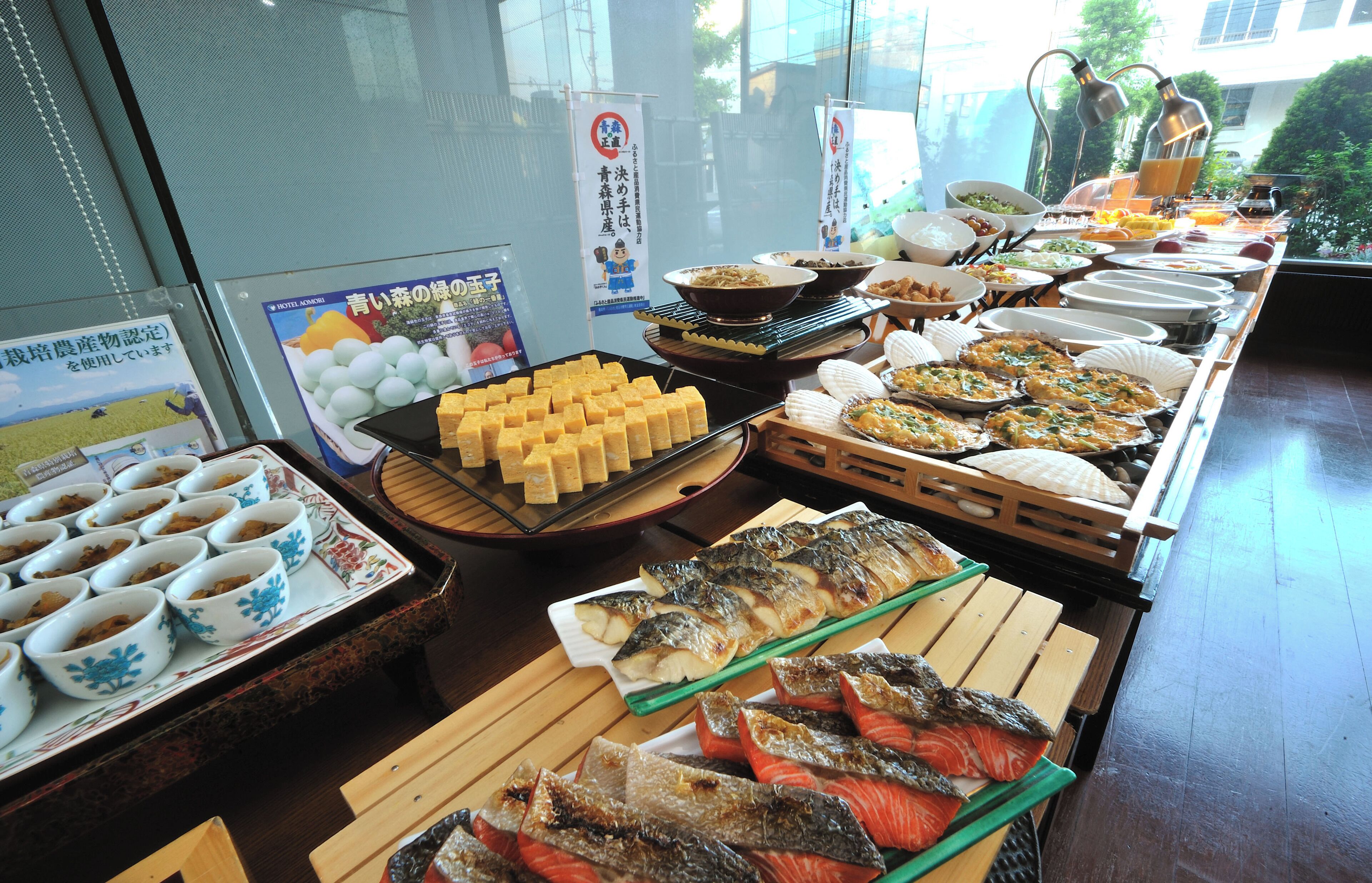 A buffet with various dishes, including fish, vegetables, and a selection of desserts.