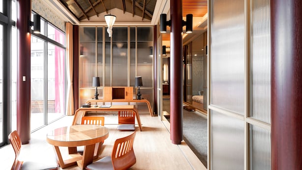 Un intérieur moderne avec une table et des chaises en bois, un canapé et une lampe.