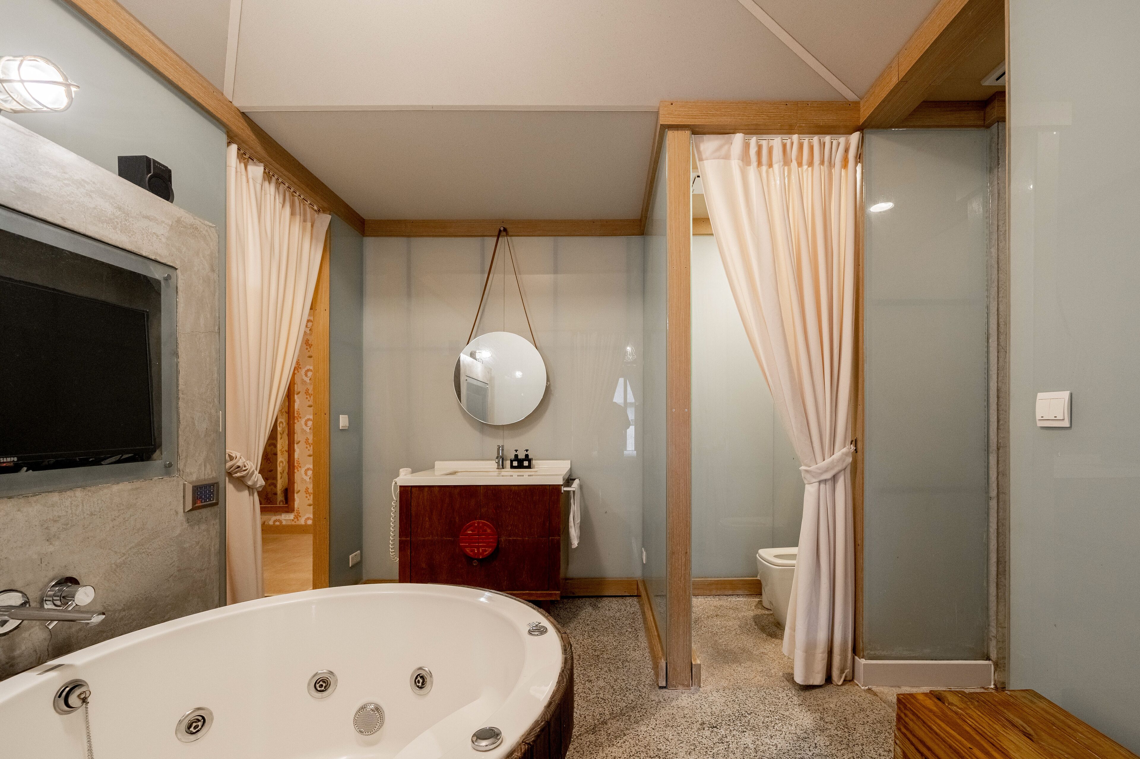 A bathroom with a bathtub, a vanity with a mirror, and a shower area.