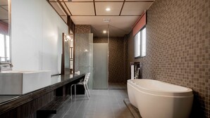 Une salle de bain moderne avec une grande baignoire, un meuble-lavabo avec un miroir et un espace douche.