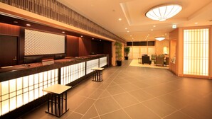 A modern hotel lobby with a reception desk, seating area, and a dining section. - Vessel Hotel Campana Kyoto Gojo (Kyoto)