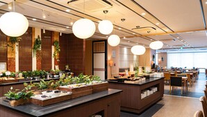 A modern restaurant with wooden counters, hanging spherical lights, and a variety of plants. - Vessel Hotel Campana Kyoto Gojo (Kyoto)