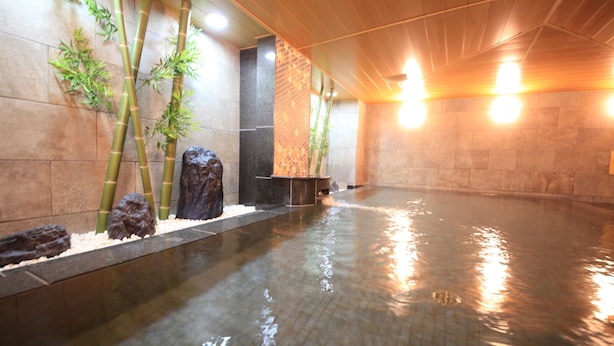 A spa area with a tiled floor, bamboo plants, and a stone wall. - Vessel Hotel Campana Kyoto Gojo (Kyoto)