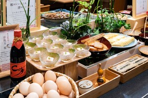 A buffet with various dishes, including eggs, bread, and a bottle of sake. - Vessel Hotel Campana Kyoto Gojo (Kyoto)