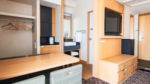 A compact hotel room with a wooden dining table, a kitchenette, a TV mounted on the wall, and a small seating area. - Vessel Hotel Campana Kyoto Gojo (Kyoto)