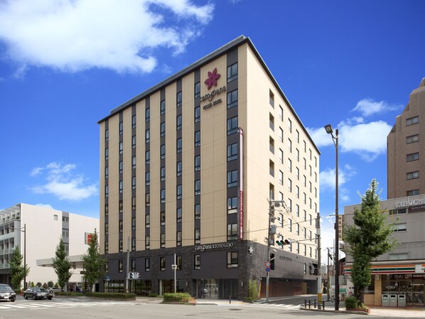 A tall hotel with a prominent red logo, multiple floors, and a modern architectural design. - Vessel Hotel Campana Kyoto Gojo (Kyoto)