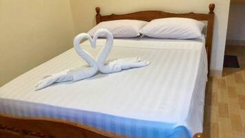 A bed with a wooden headboard and a white bedspread.