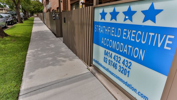 A sign for Strathfield Executive Accommodation with contact numbers and a website URL. - Strathfield Executive Accommodation (Strathfield)