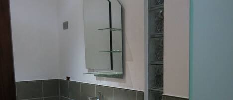 A bathroom with a white sink, a mirror, and a toilet.