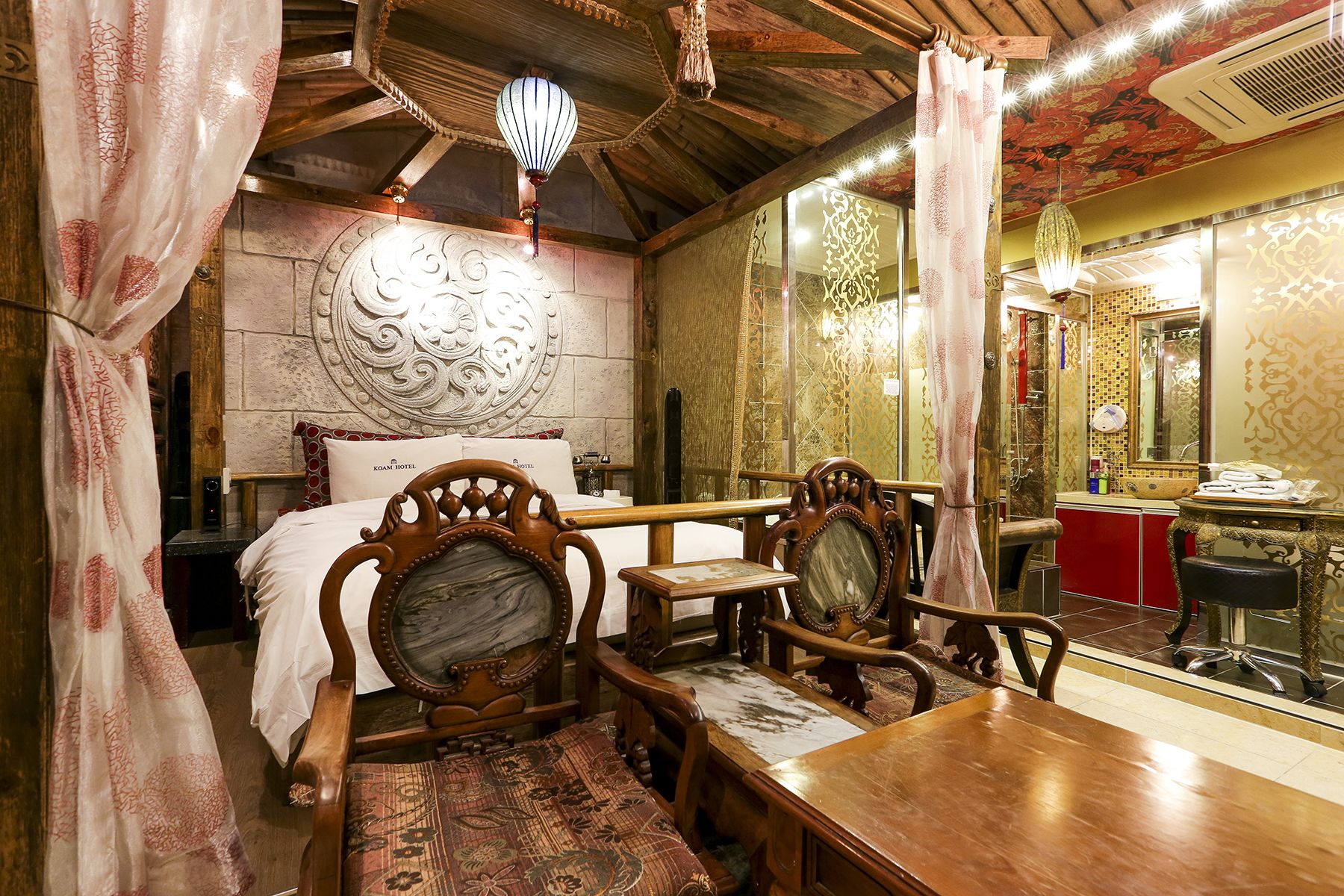 Una habitación tradicional con cama, muebles de madera y un espejo.