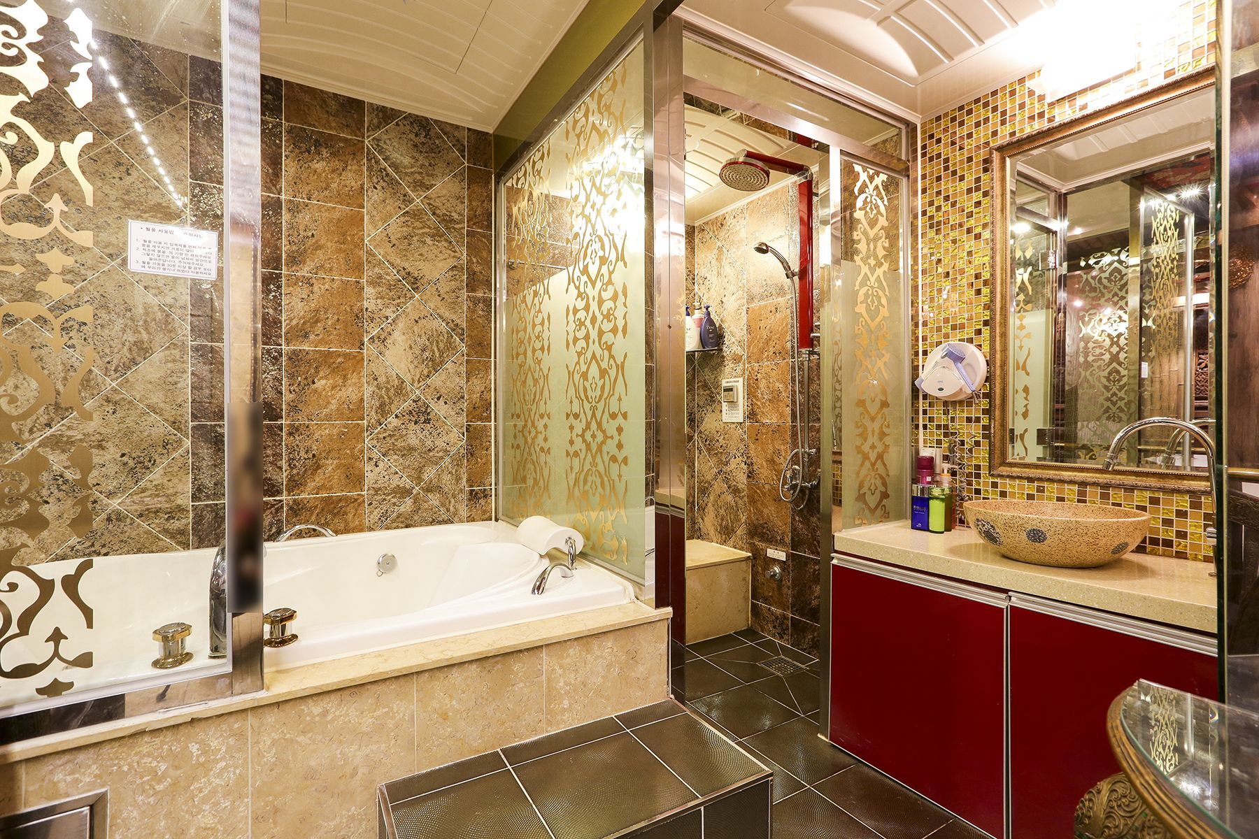 Une salle de bain équipée d’une baignoire, d’une douche et d’un meuble-lavabo avec un grand miroir.