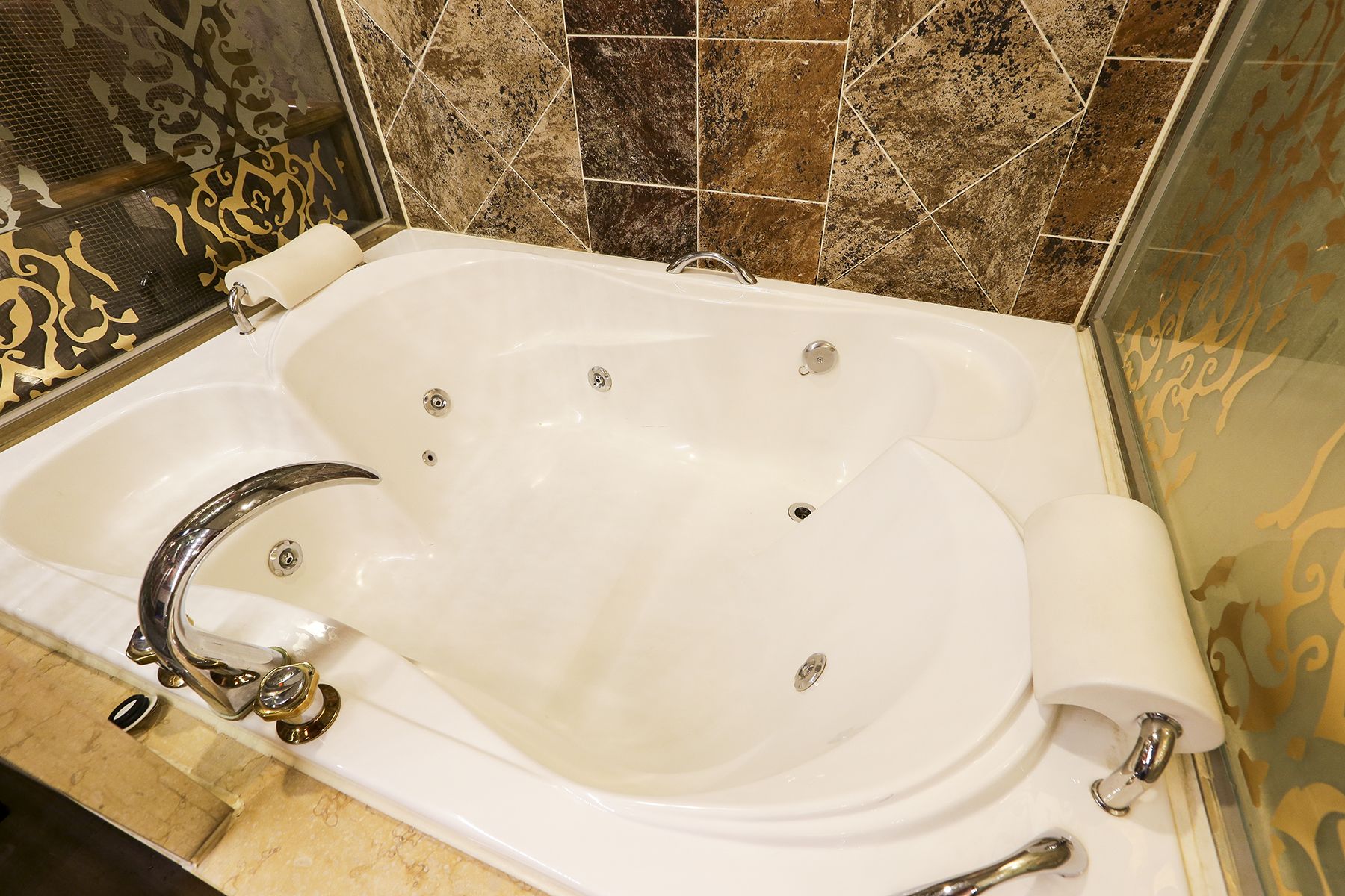 Una bañera blanca con un grifo cromado y un rollo de papel higiénico a un lado.