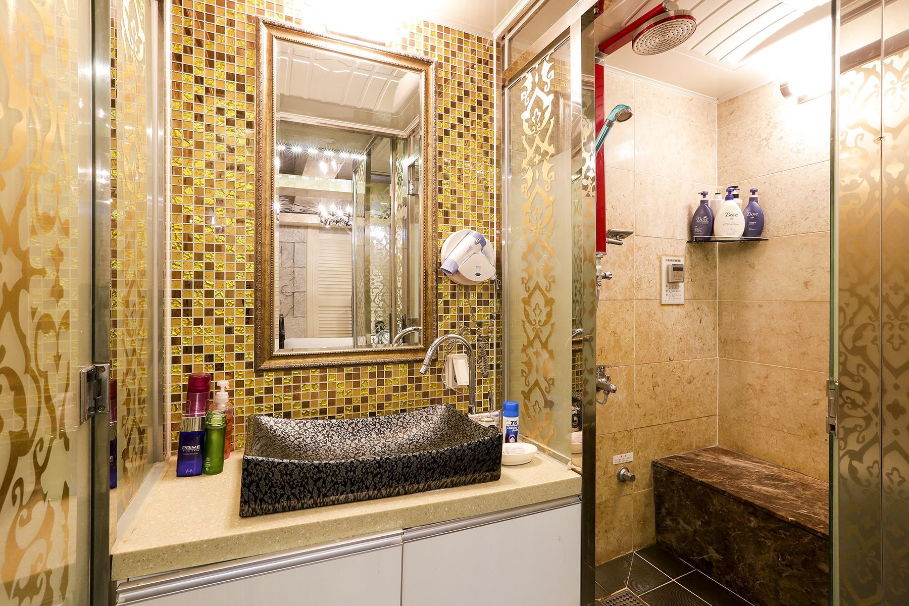 A bathroom with a sink, mirror, and shower.