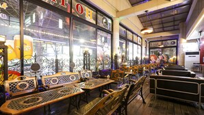 Un ristorante con tavoli e panche in legno, un'area bar e vista sulla strada.