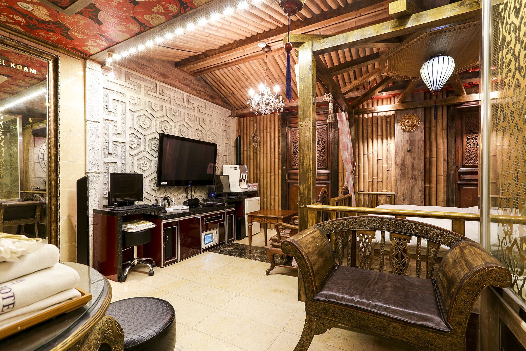 Ein traditionelles Interieur mit Holzboden, einem Fernseher, einem Schreibtisch mit Computer und einem gepolsterten Sessel.