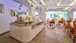 Ein moderner Essbereich mit einem Buffet, Holzsesseln und Blick ins Freie.