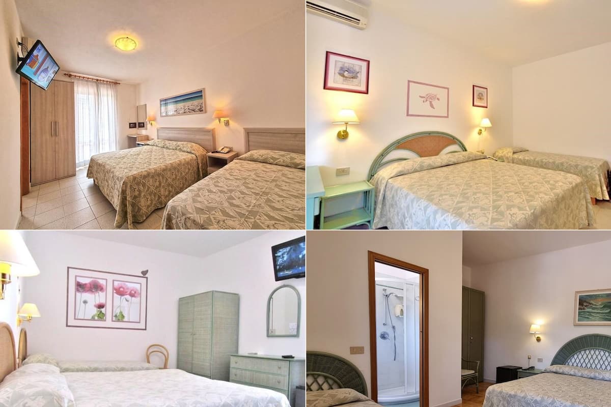 Ein Hotelzimmer mit zwei Betten, einem Fernseher, einem Kleiderschrank, einem Spiegel und einer Dusche.