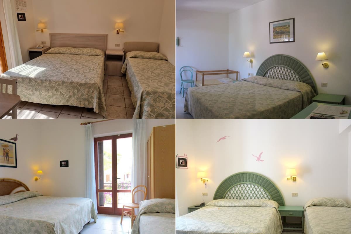 Ein Hotelzimmer mit zwei Betten, einem Sessel, einem Tisch und einer Tür zu einem Außenbereich.