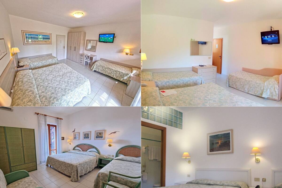 Ein Hotelzimmer mit zwei Betten, einem Schreibtisch, einem Fernseher und einem Badezimmer.