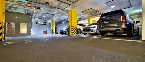 Eine mehrgeschossige Parkgarage mit gelben Säulen und schwarz-gelb gestreiften Absperrungen.
