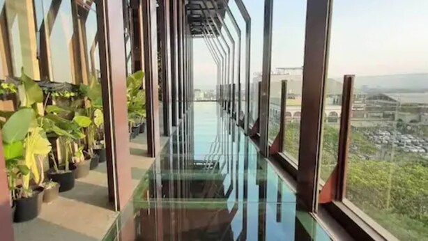 Un edificio moderno con un pasillo de vidrio y plantas en macetas.