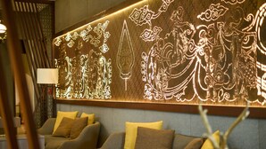 A modern interior with a wall-mounted light display and two sofas with cushions. - de Java Hotel Bandung (Bandung)