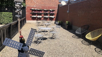 Relax in a charming outdoor space with a brick wall, wooden fence, and comfortable seating options.