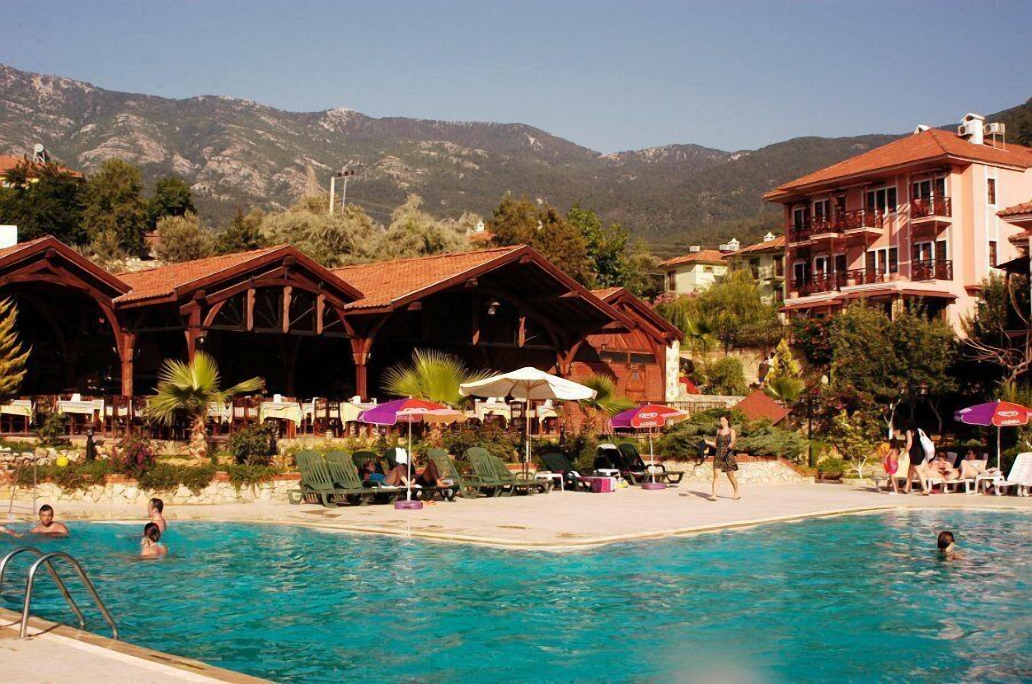 Un resort con piscina, zona de estar al aire libre y vistas a la montaña.