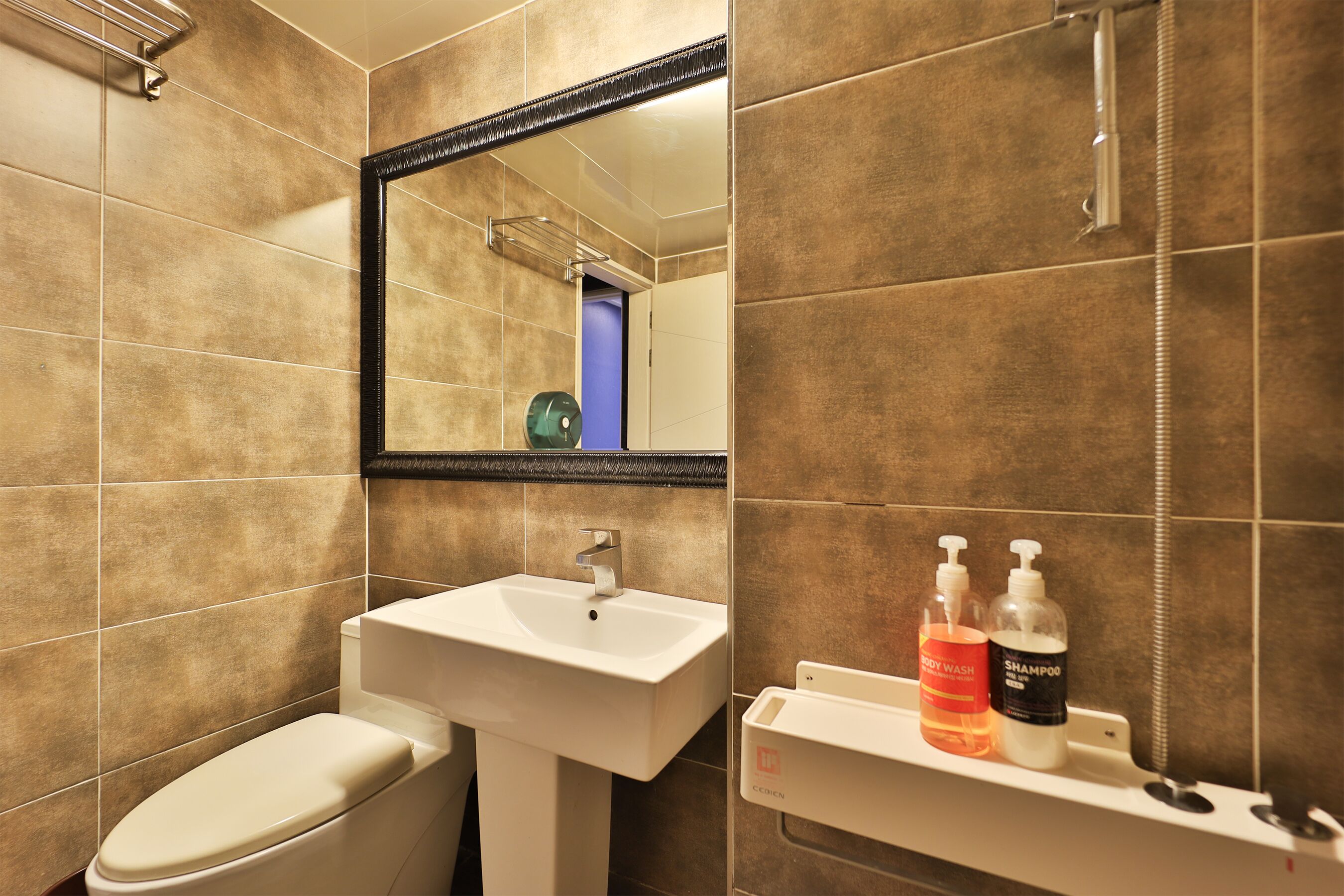 A bathroom with a white sink, a mirror, and toiletries on the countertop.