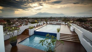 A rooftop pool with a view of a cityscape and mountains in the distance. - Maxone Hotels at Malang (Malang)