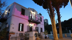 A two-story building with a balcony and a staircase leading to the entrance. - Santa Maria Guest House (Haifa)