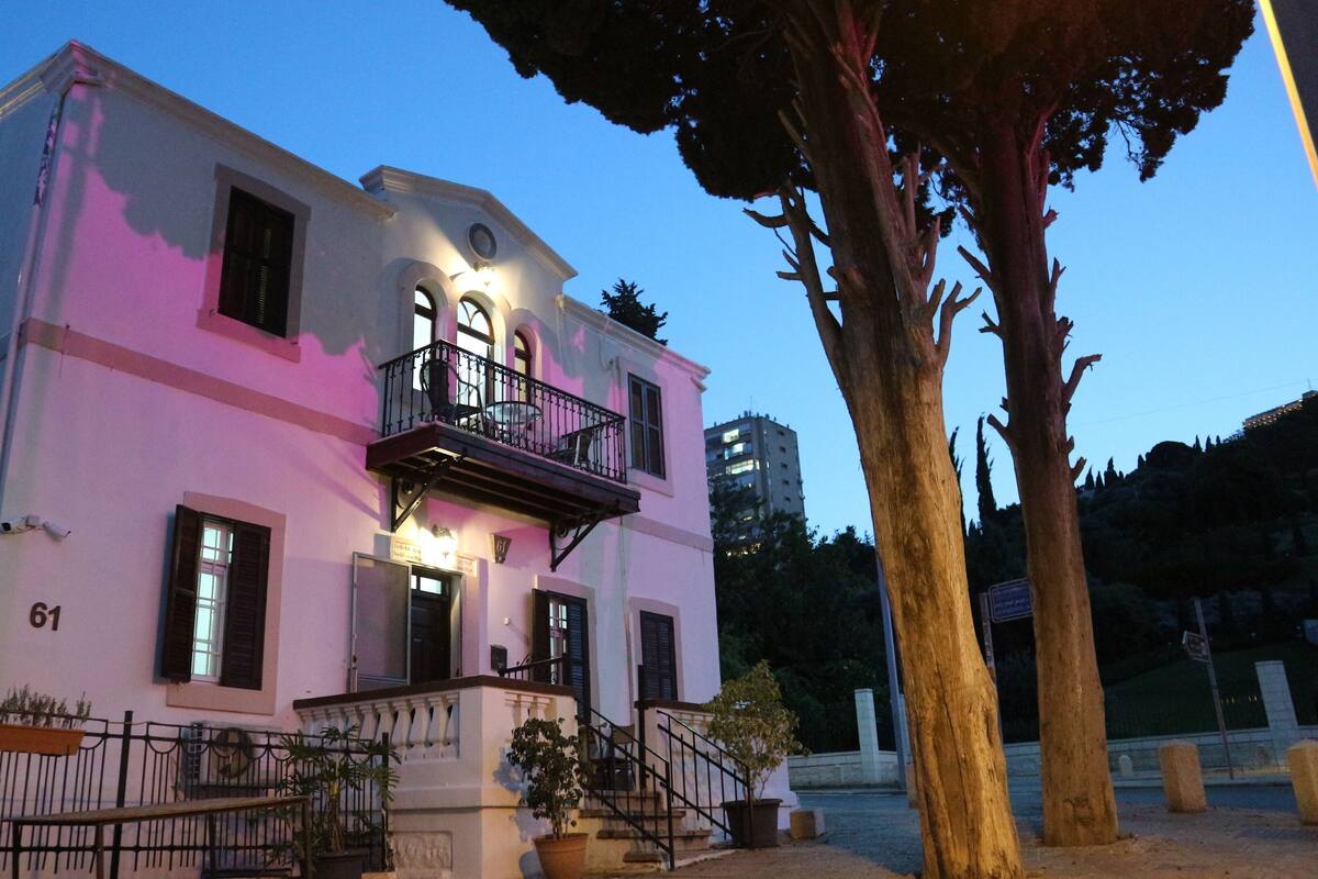 A two-story building with a balcony and a staircase leading to the entrance.