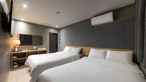 A hotel room with two beds, a desk with a lamp, a mirror, and an air conditioning unit. - About Stay Seoul Station (Seoul)