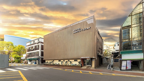 A modern hotel with a prominent 'Hotel About Stay' sign, a spacious entrance, and a view of the surrounding urban area. - About Stay Seoul Station (Seoul)