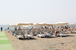 Ubicación cercana a la playa, tumbonas, sombrillas y toallas de playa