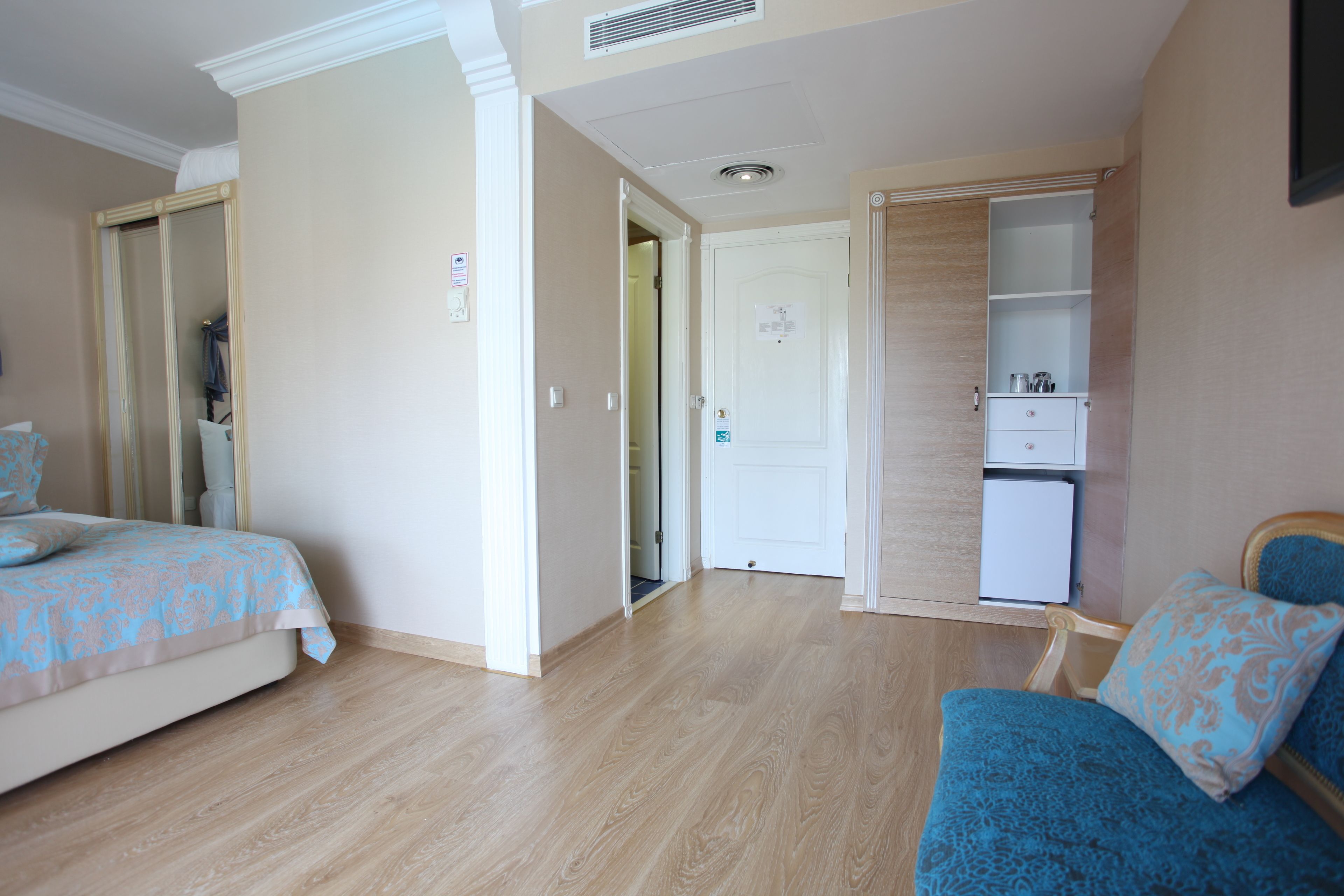 Un dormitorio con dos camas, un armario y una pequeña kitchenette.