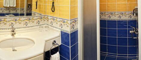 Ein Badezimmer mit Waschbecken, Spiegel und Dusche.