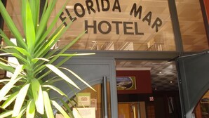 The exterior of Florida Mar Hotel with a clear sign, a potted plant, and a glimpse of the interior. - Florida Mar Hotel (Sanxenxo)