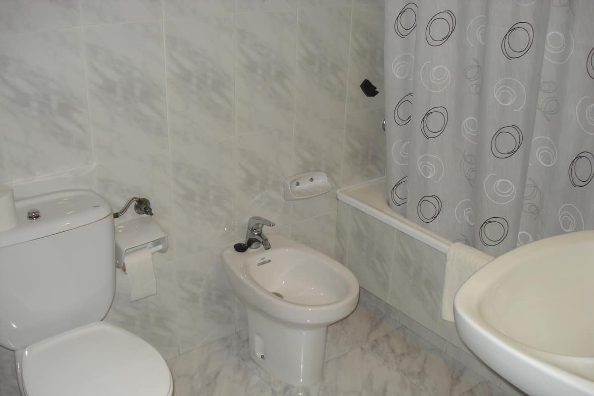 Un baño con inodoro, bidé y lavabo.