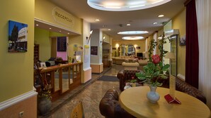 A hotel lobby with a reception desk, seating areas, and a reception sign. - Hotel Vila Ruzica (Crikvenica)